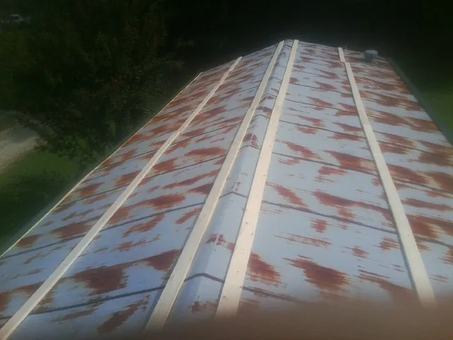 Rusted metal roof panels with new wood purlins before replacement — Storm Damage Roof Repair in Clarksville by Roofing Brothers
